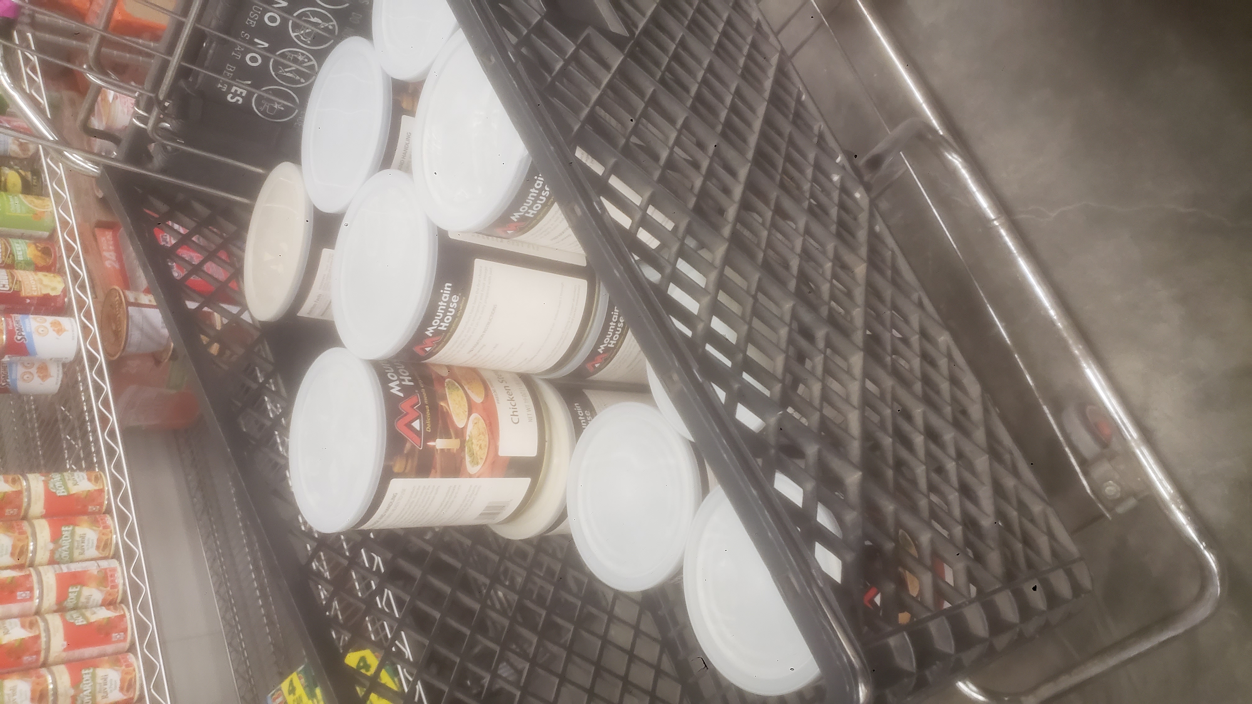 Shopping cart with cans of freeze dried meals in it.